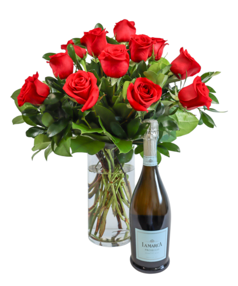 An arrangement of twelve red roses and green foliage in a white vase, paired with a bottle of 'Lamarca Prosecco Champagne'.